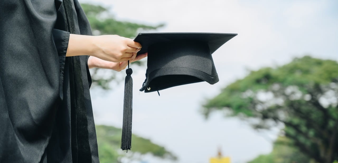 Woman holding graduation cap.