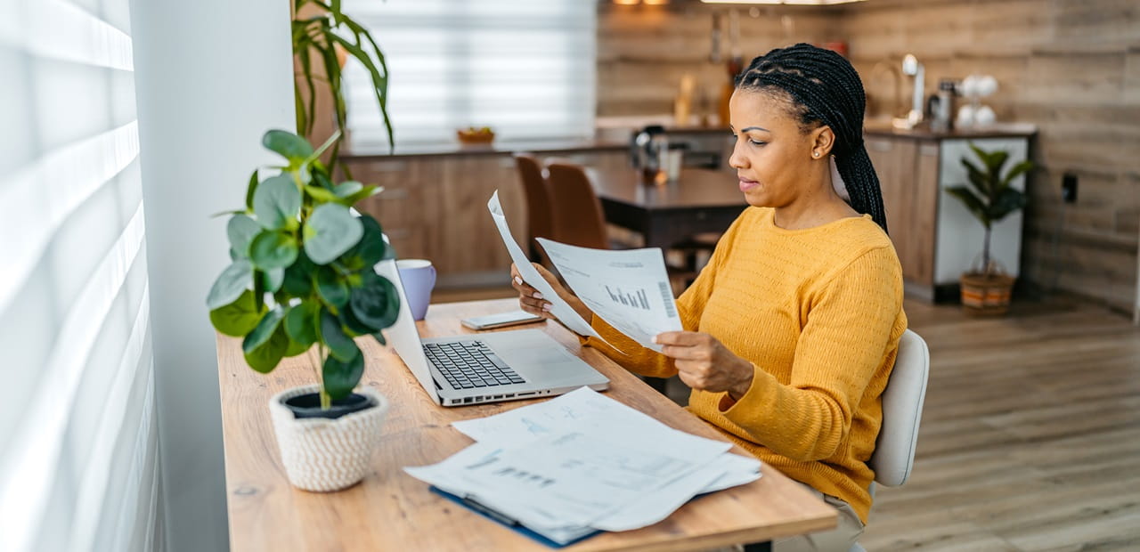 Woman sitting at desk reviewing documents.