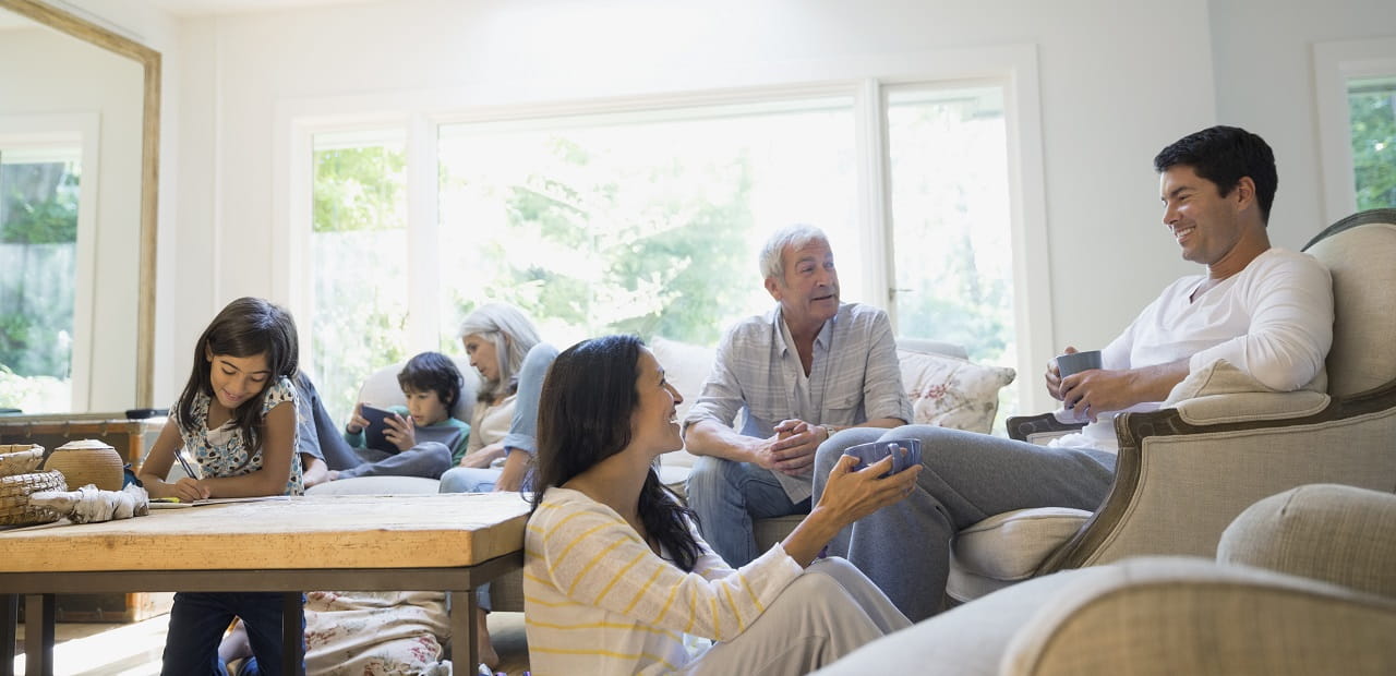 Multiple generations of a family gather together for quality time in their living room