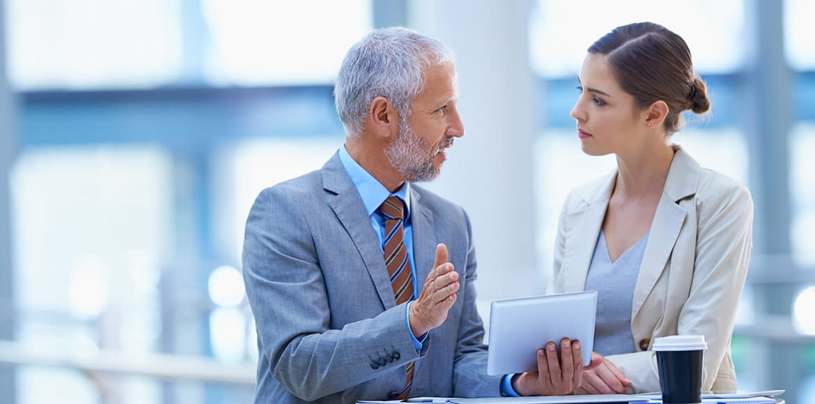 Two coworkers discussing plans on a tablet